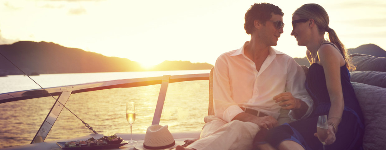 un couple s'asseyant sur un bateau au coucher du soleil